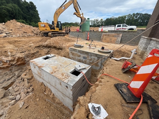 Concrete septic tanks being installed beside a commercial building by Samples Septic Service LLC