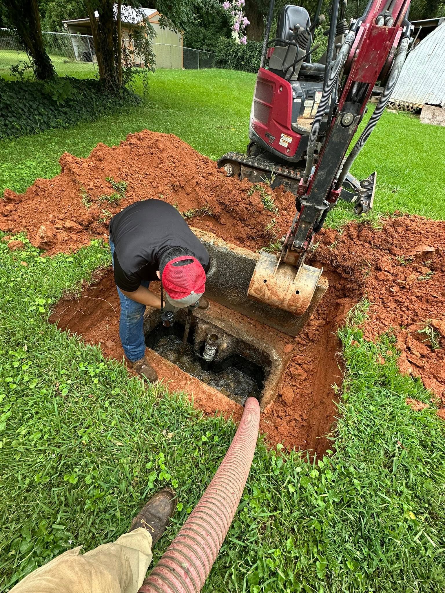 Samples Septic technician pumping a septic tank with a vacuum hose